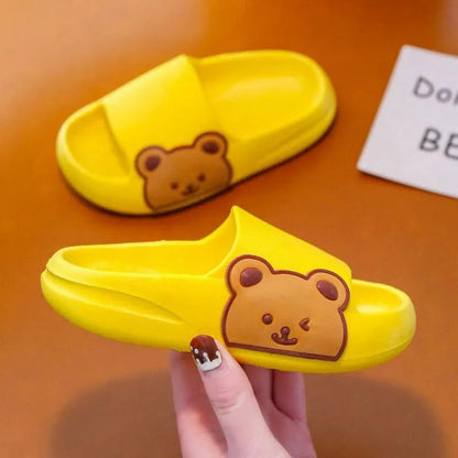 Yellow children's slippers with bear design, showcasing comfort and playful charm.