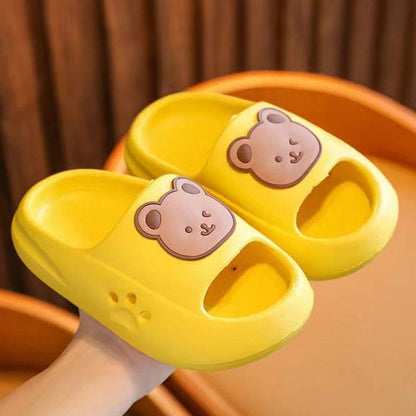 Bright yellow children's slippers with a cute bear design, emphasizing comfort and lightweight materials.