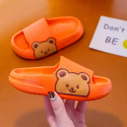 Bright orange children's slippers with bear design, showcasing comfort and style for kids.