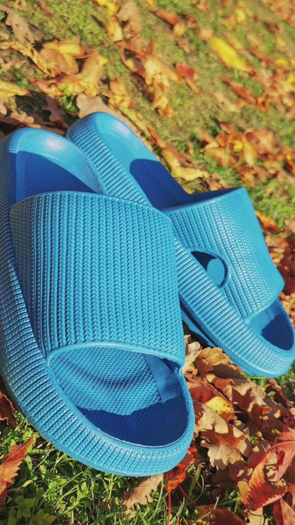 Blue Wolkenflitzer slippers on autumn leaves, offering comfort and cushioning for a gentle walking experience.